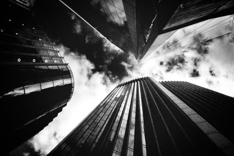Low angle view of threee skyscrapers against skyin bnw