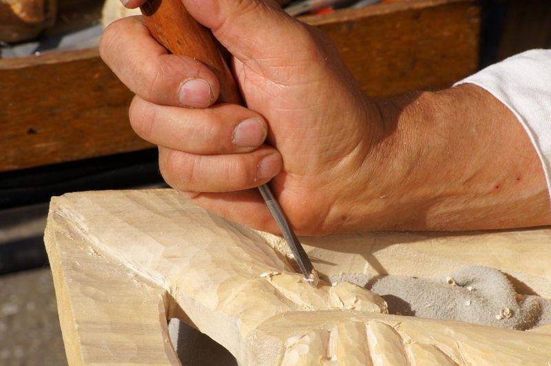 Cropped image of craftsperson carving wood at workshop