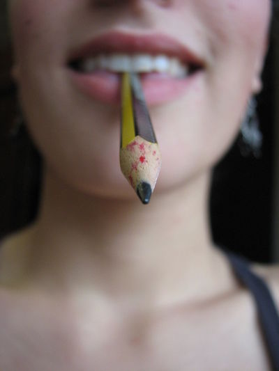 Close-up of woman with a pencil in her mouth