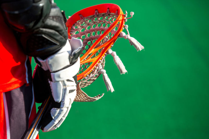 Midsection of player holding lacrosse sports equipment