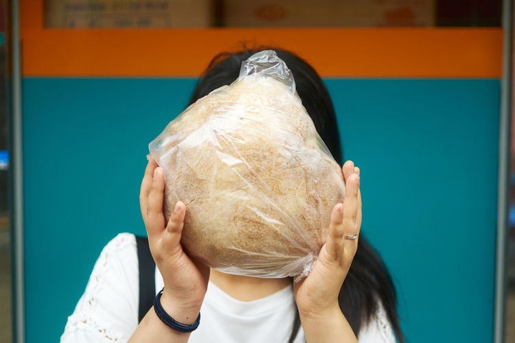 Woman covering face with food
