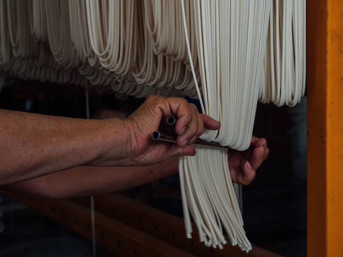 Cropped hands of person preparing pasta in factory