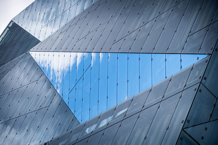 Glass building with reflection of cloudy sky