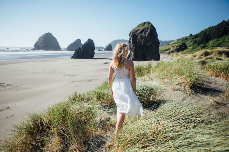 Rear view of young woman walking at beach