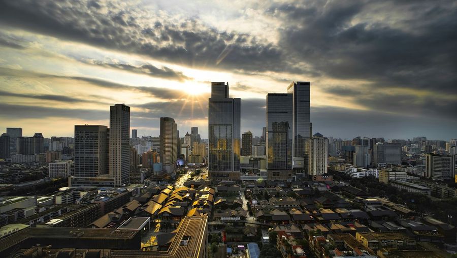 Aerial view of cityscape against cloudy sky