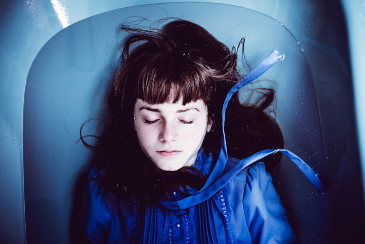 High angle view of woman in bathtub with eyes closed