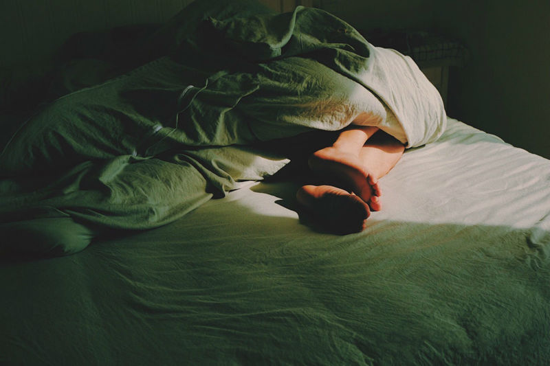 Low section of woman sleeping on bed