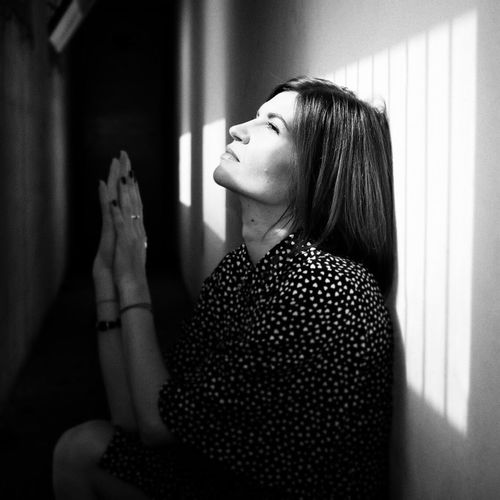 Thoughtful woman sitting against wall