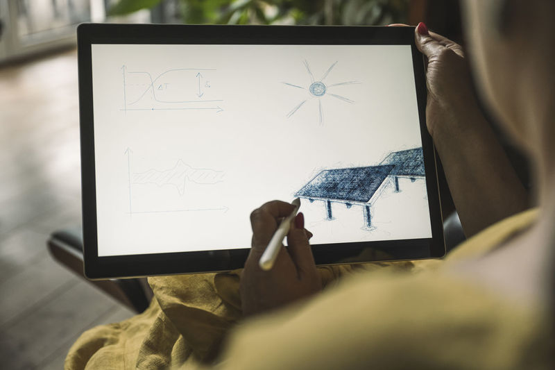 Freelancer making solar panel on graphics tablet at home office