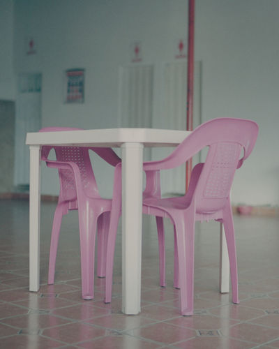 EMPTY CHAIRS AND TABLE AGAINST TILED FLOOR