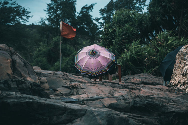 Flag by umbrella on rock formation