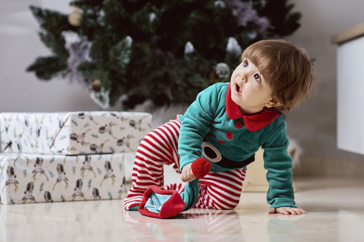 Cute boy with toy on floor at home