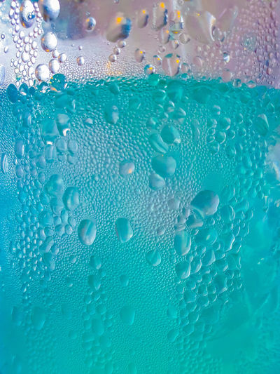 Close-up of water drops on blue surface
