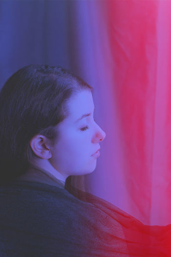 Young woman with closed eyes standing indoors