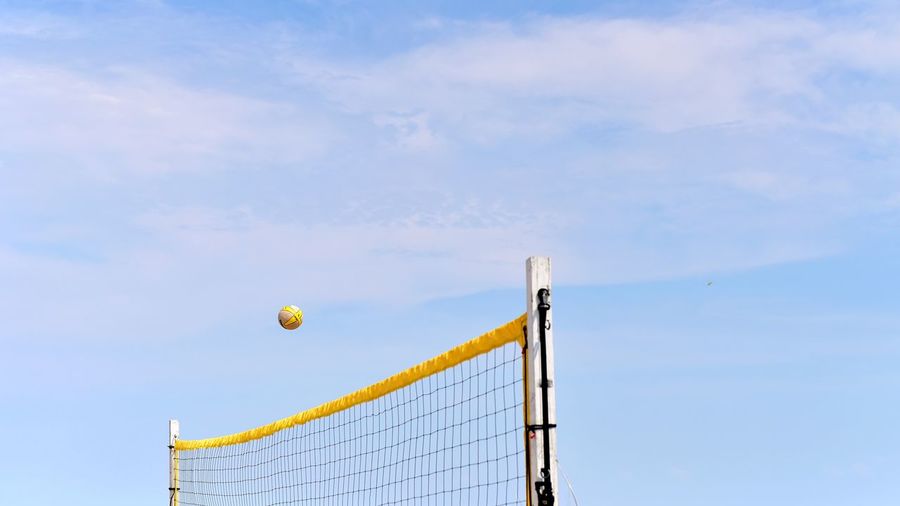 Volleyball in air over volleyball net