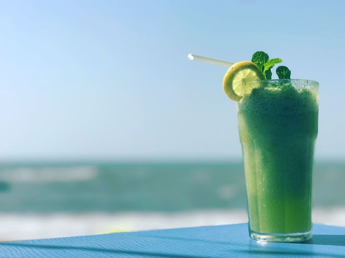 Close-up of mojito on table against sea