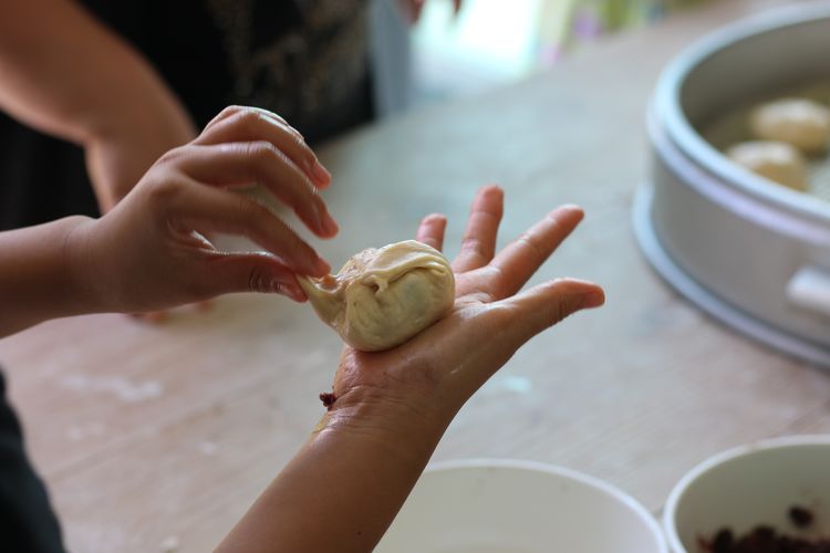 Cropped image of girl making dumpling at home