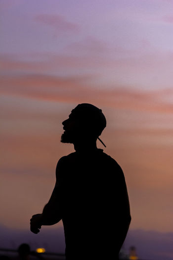 Silhouette man standing against sky during sunset