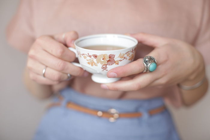 Close-up mid section of a woman holding tea cup
