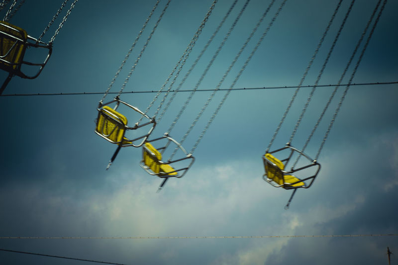Low angle view of overhead cable cars against sky