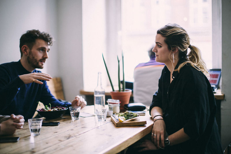 Young couple sitting on table at restaurant