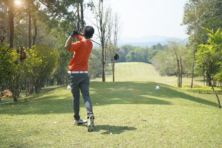 Rear view of man standing on golf course