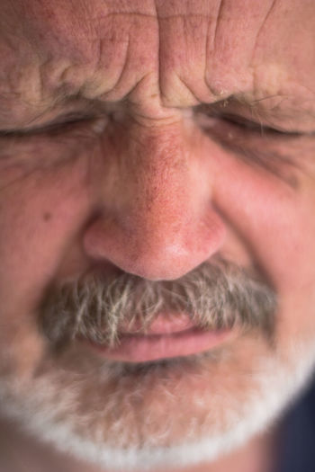 Close-up of angry senior man grimacing