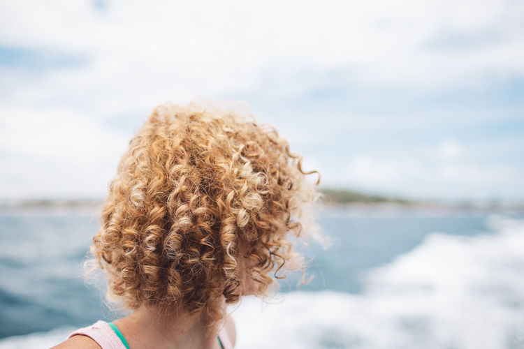 Portrait of woman looking at sea against sky