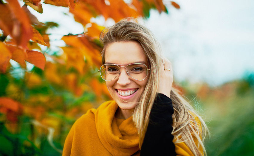 Portrait of smiling woman against tree