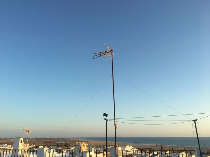 Low angle view of telephone pole against clear blue sky in spain
