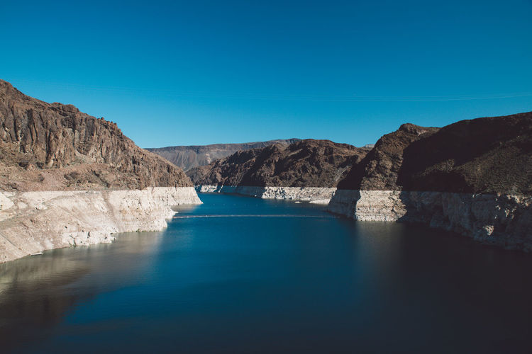 Colorado river amidst mountains against blue sky