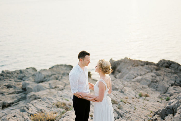 Side view of couple standing at beach