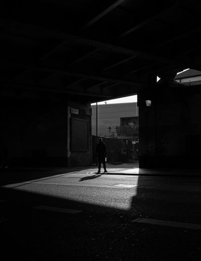 Side view of silhouette man walking in illuminated building