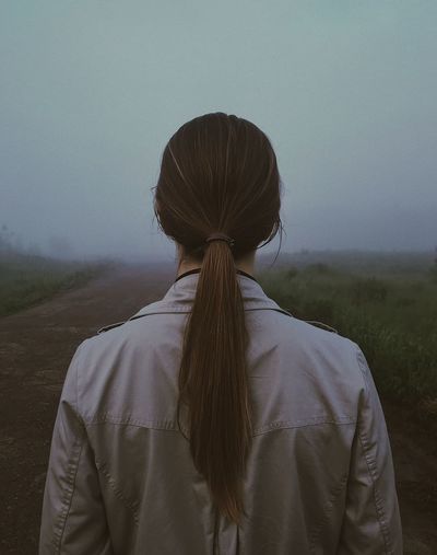 Rear view of woman standing against sky