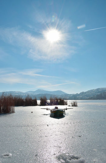 Boat in snowy lake on a sunny day