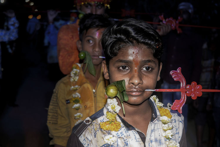 Close-up of boy with pierced metal through cheek during religious festival