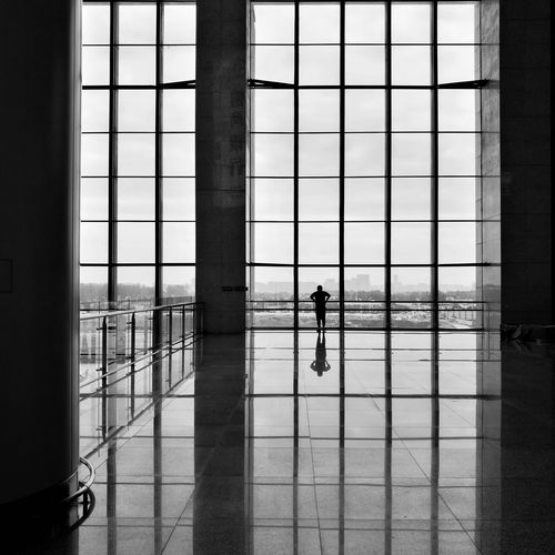 Man looking through window against sky