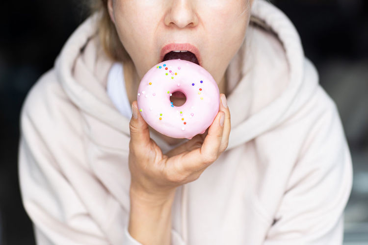 Midsection of woman holding donut