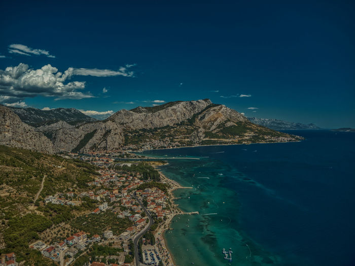 Scenic view of sea and mountains against blue sky