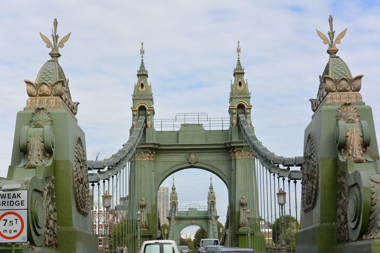 Cars moving on hammersmith bridge against cloudy sky
