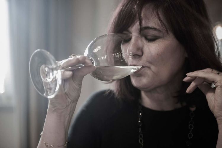 Woman drinking white wine at home