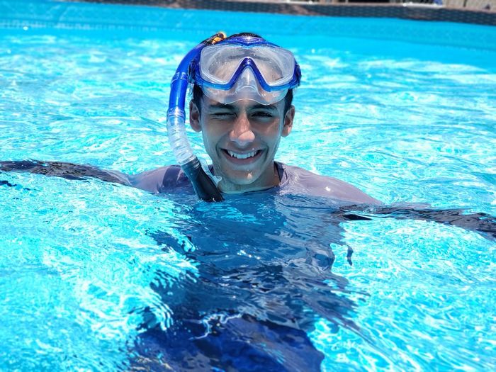 Portrait of smiling boy snorkeling in swimming pool
