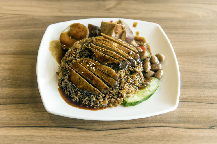 Close-up of braised duck rice served in plate on table