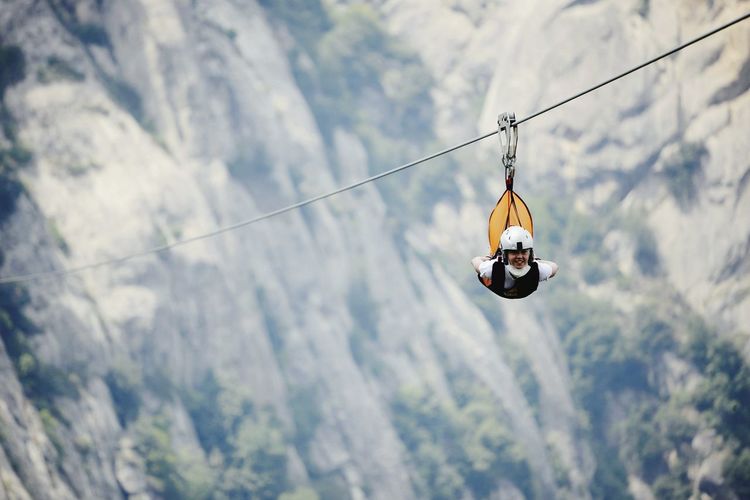 Low angle view of young woman on zip line