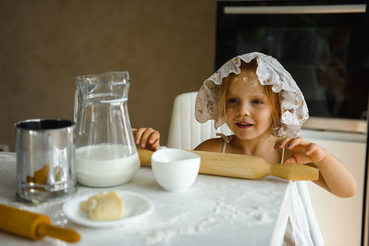 Little girl cooking pizza in the kitchen