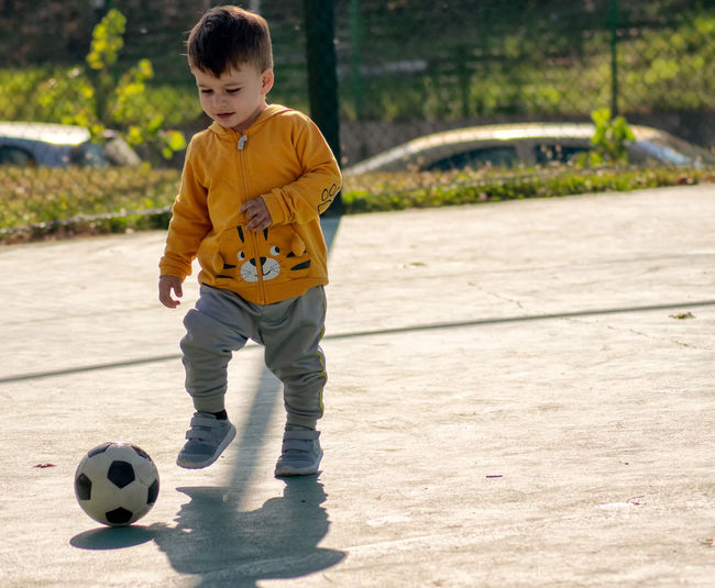 Boy playing soccer ball on field