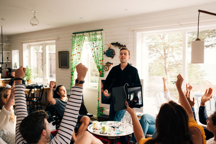 Happy friends celebrating success of man in cottage