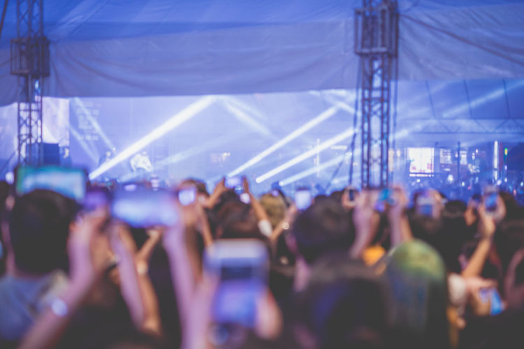 Nightlife and youth activity with backside of crowd in concert hall during show 