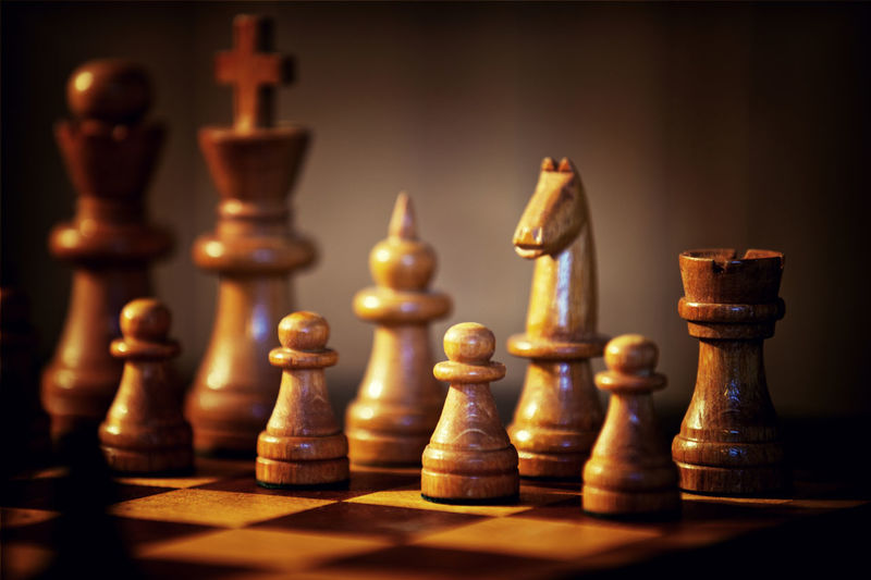 Close-up of wooden chess pieces on board