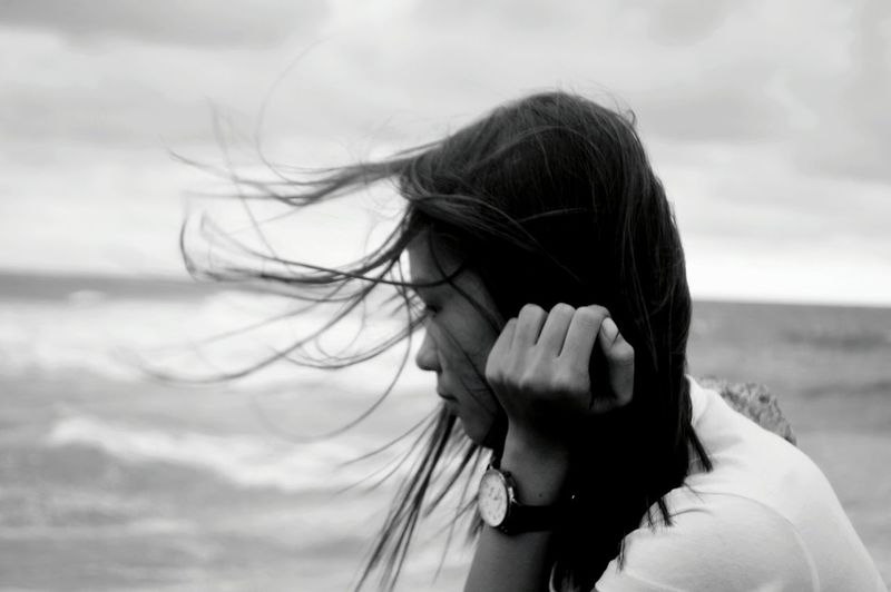 Side view of thoughtful woman against sea